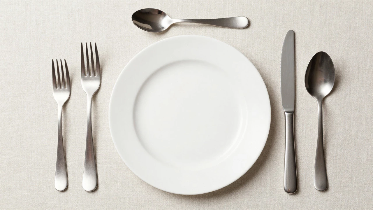 Formal table setting with forks, knives, and spoons arranged around a white plate